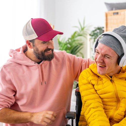Disabled man and caregiver during art therapy session with music