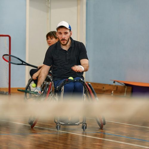 People in wheelchair playing tennis on court. Wheel Chair Tennis For Disabled.